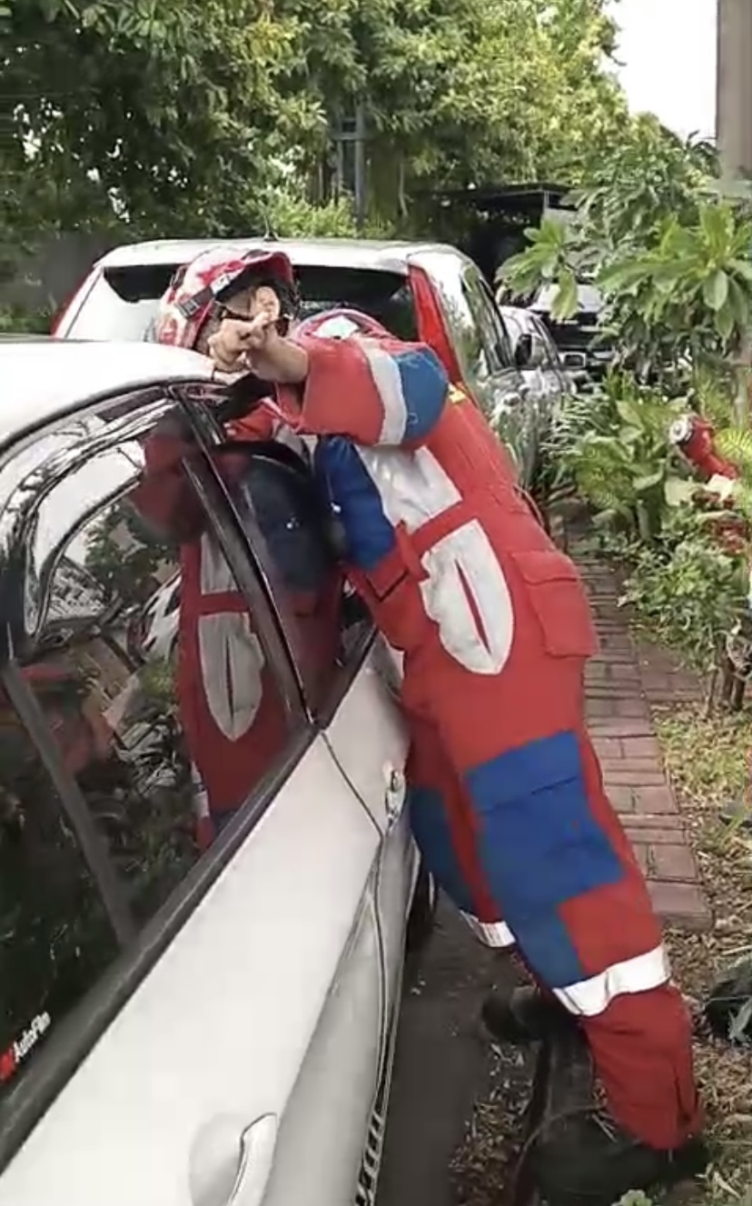 Petugas Gulkarmat DKI mencoba mengambil kunci di dalam mobil yang terkunci.