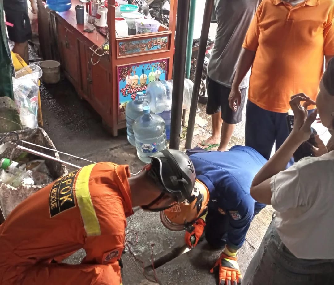 Petugas DPKP Kota Depok mengevakuasi kunci yang masuk gorong-gorong.