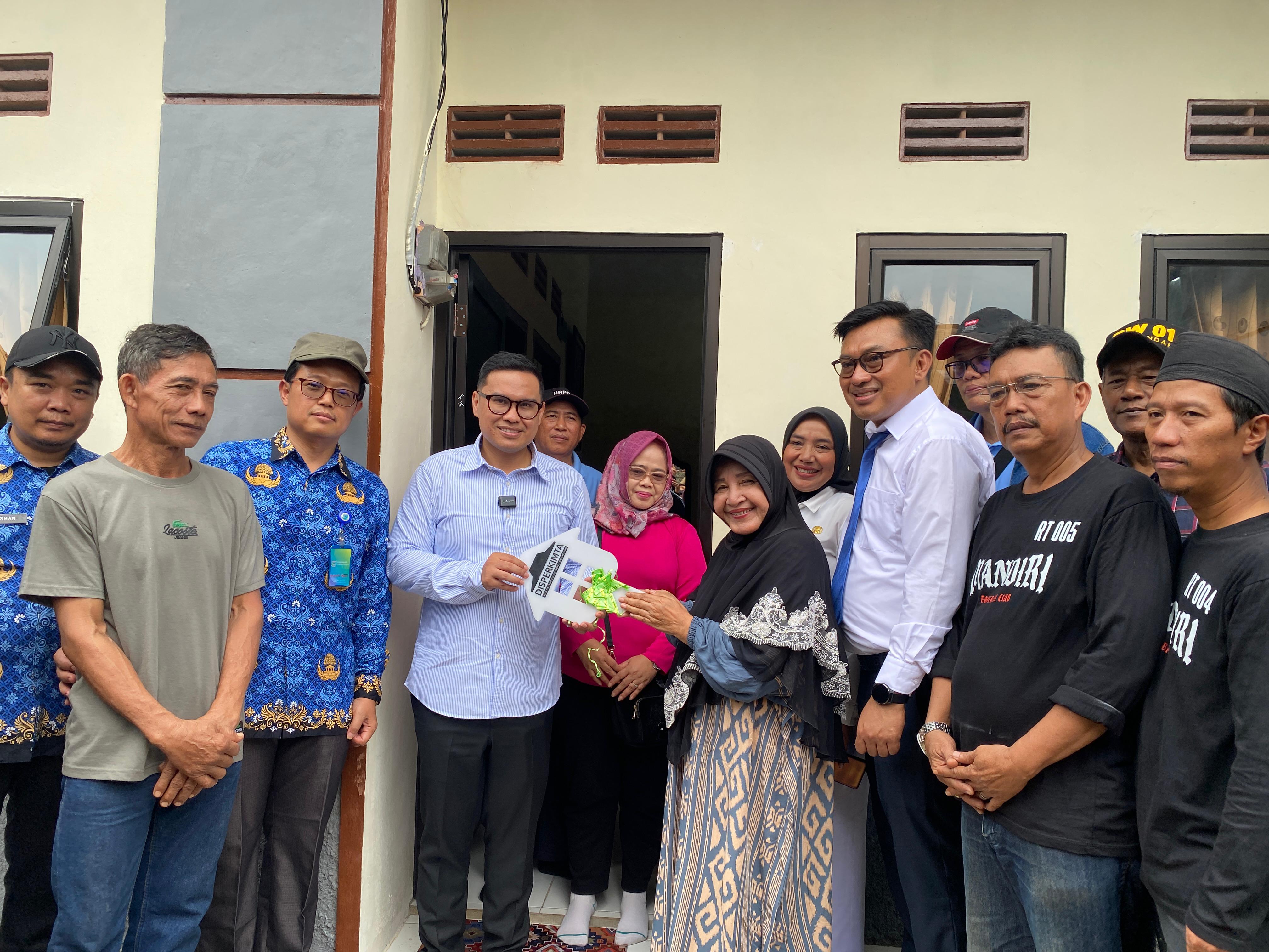 Wakil Wali Kota Tangsel Pilar Saga Ichsan (tengah) menyerahkan simbolis kunci kepada penghuni rumah pada program bedah rumah 2025