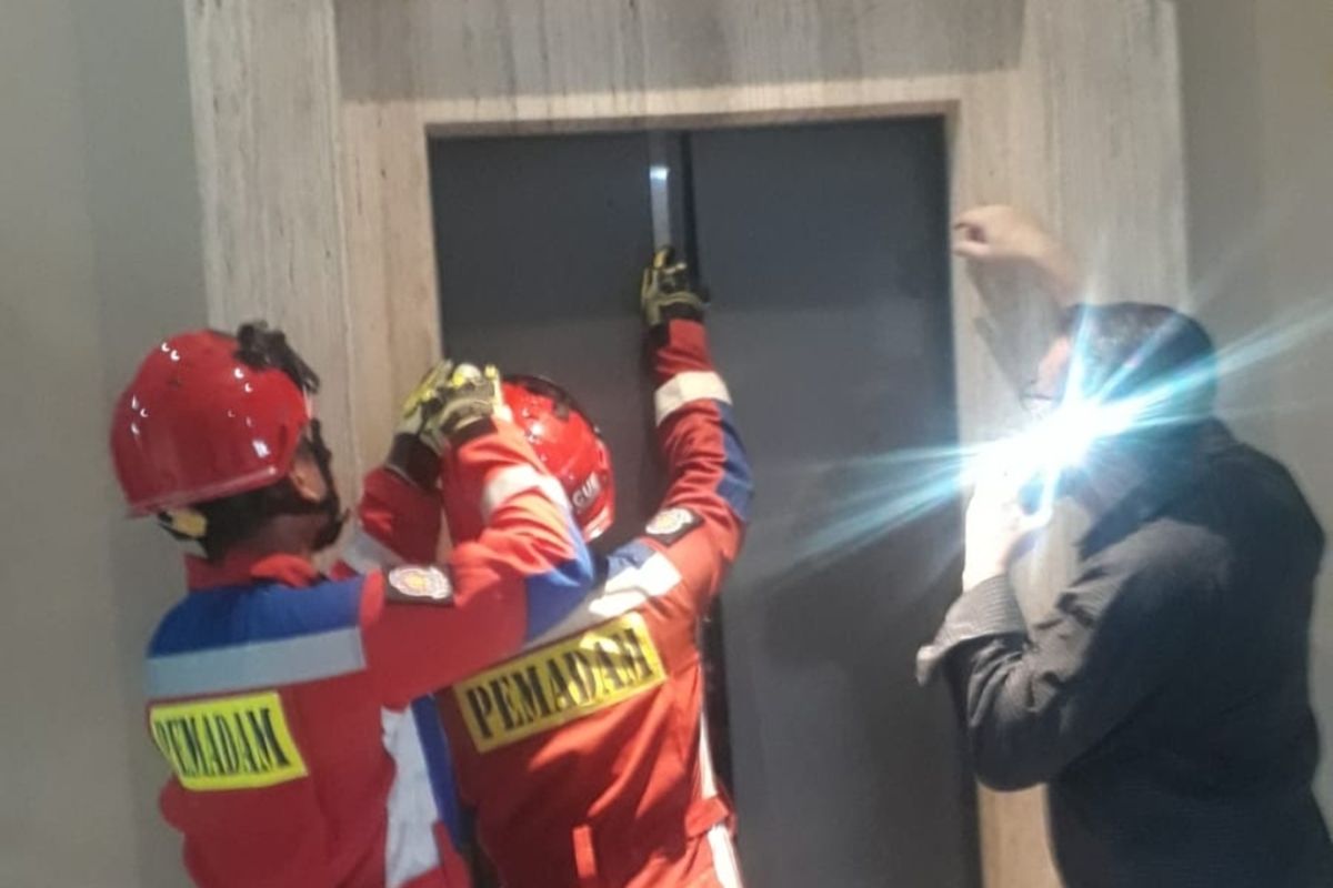 Petugas Gulkarmat DKI berusaha membuka lift untuk membantu penghuni yang terjebak di dalam lift gedung kawasan Karet Kuningan, Jakarta Selatan.
