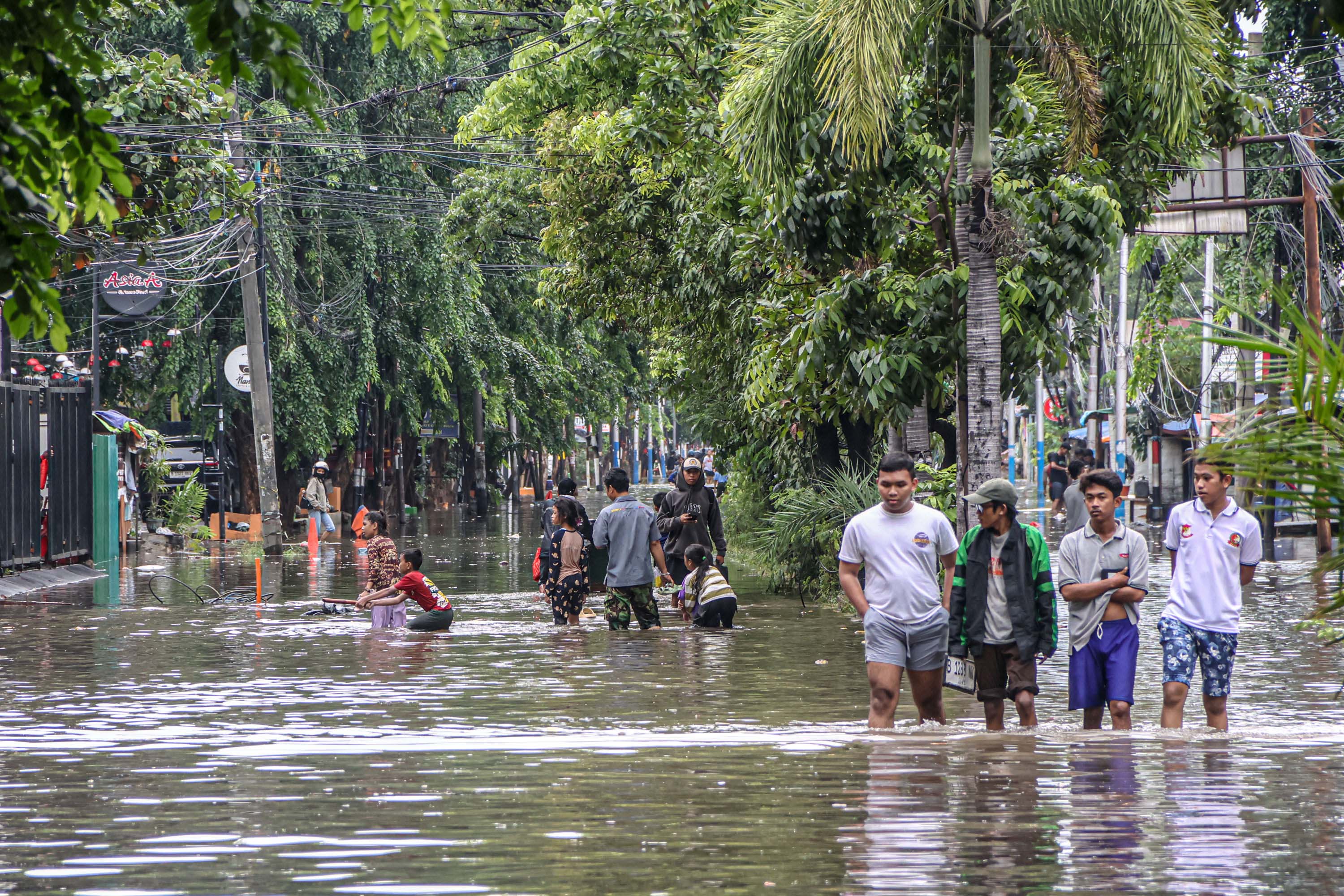 Genangan banjir dampak hujan deras tampak terjadi di Jalan Tubagus Angke, Jakarta Barat, Minggu (18/1).