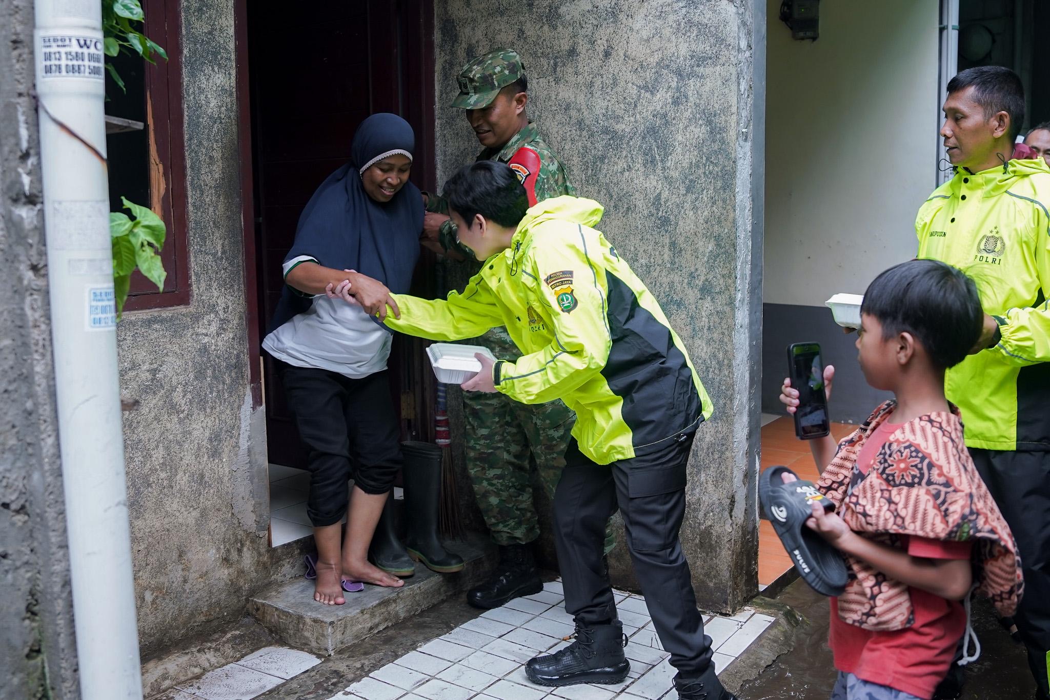 Kapolsek Pesanggrahan Kompol Seala Syah Alam, mendatangi rumah warga yang terdampak banjir untuk membersihkan bantuan makanan.