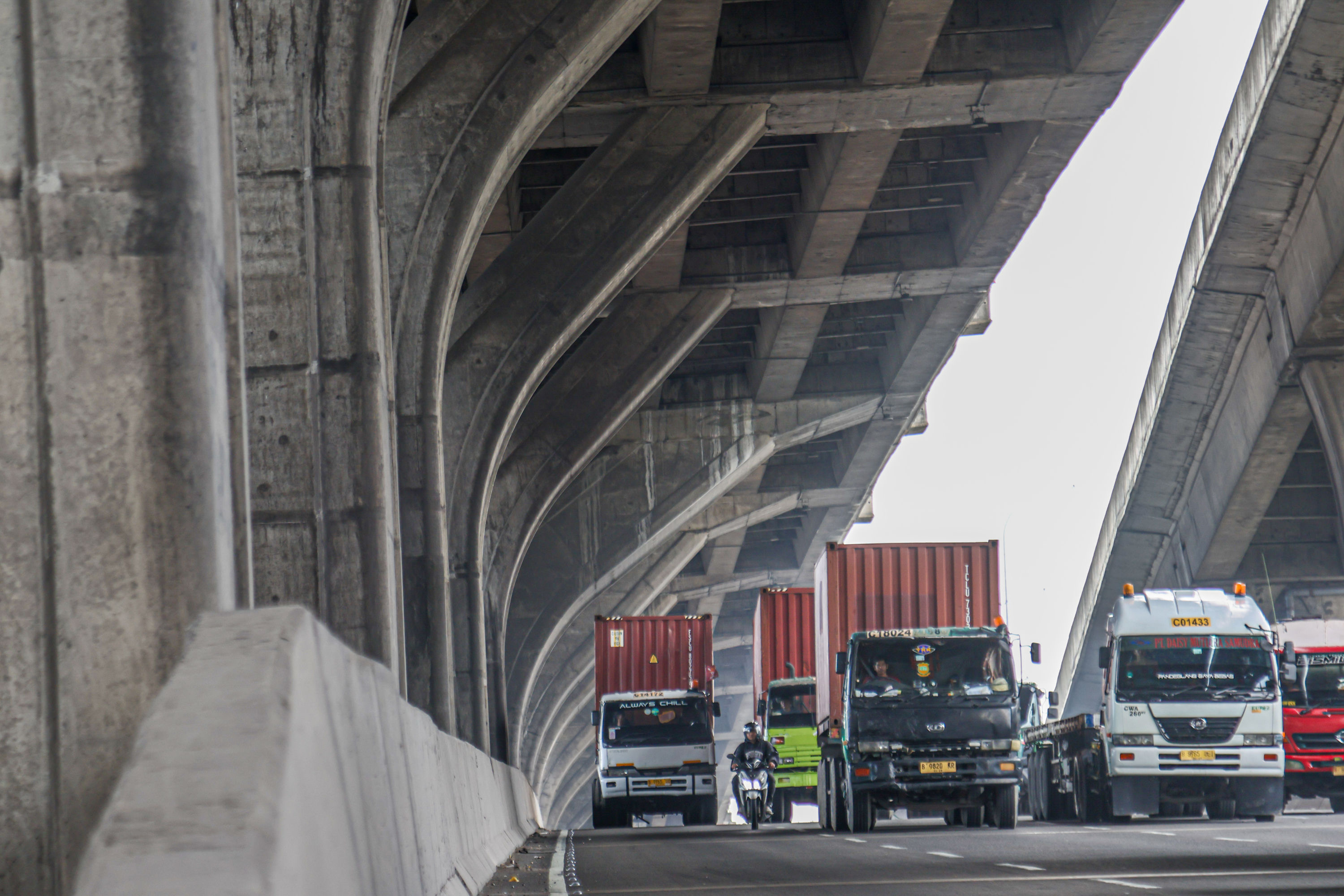 Truk besar melintas di jalan tol kawasan Cakung, Jakarta.