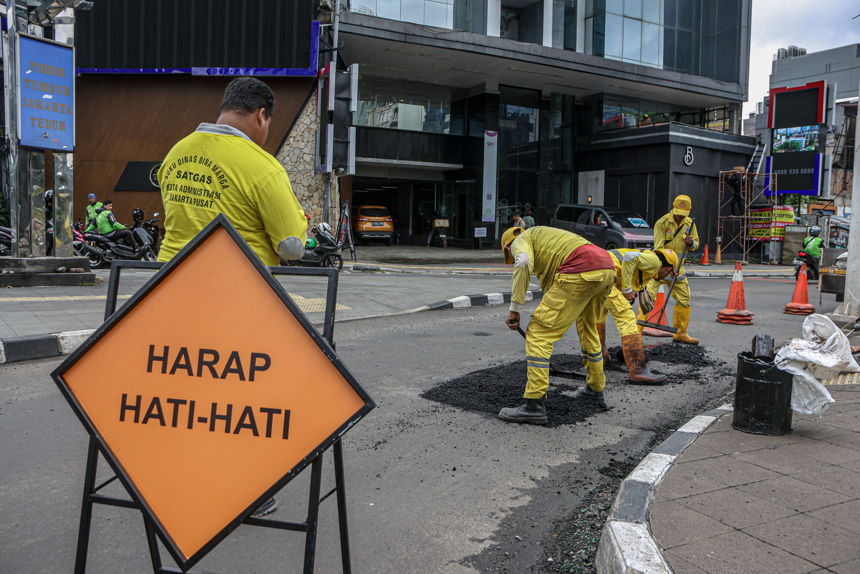 Petugas Dinas Bina Marga DKI Jakarta menambal jalan yang berlubang di Jalan Blora, Jakarta Pusat.