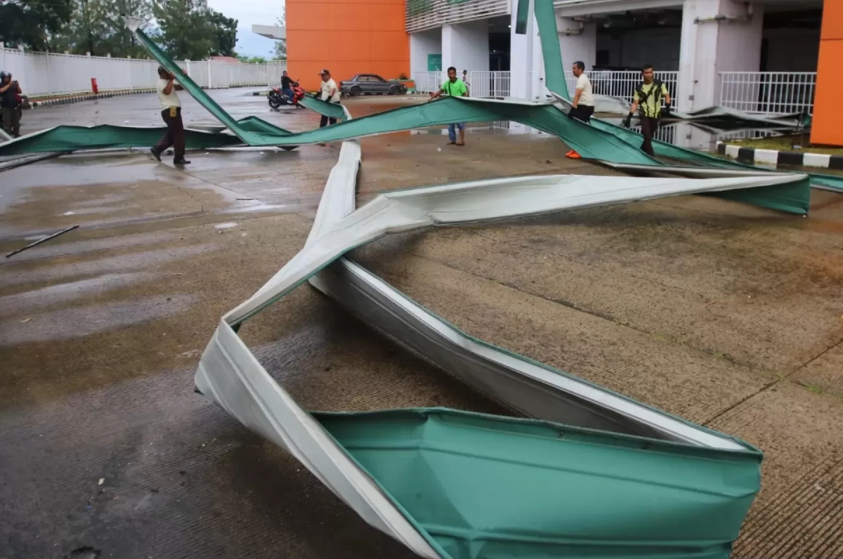 Petugas merapikan atap stadion Pakansari, Kecamatan Cibinong, Kabupaten Bogor, yang roboh akibat angin dan hujan deras, Kamis (12/2). (Hendi Novian/Radar Bogor)