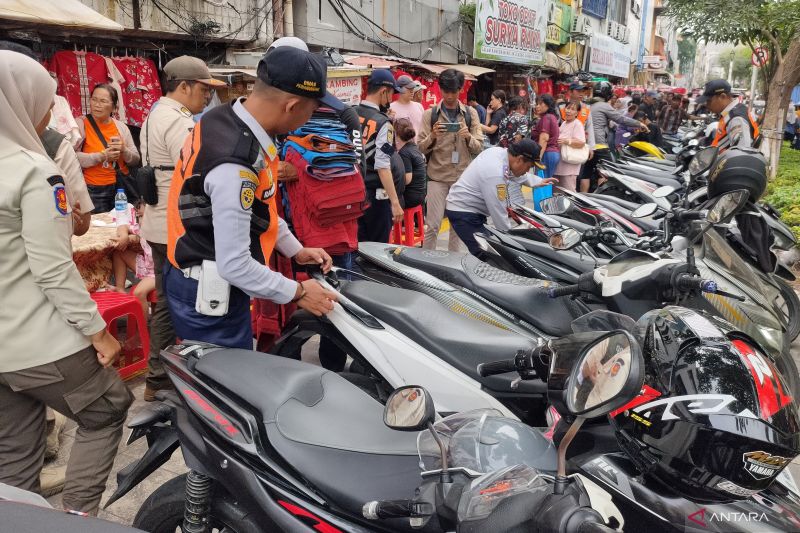 Petugas gabungan Pemkot Jakbar menggelar operasi cabut pentil terhadap puluhan sepeda motor yang diparkir liar di trotoar kawasan Pecinan Glodok, Tamansari, Jakbar, Rabu (11/2). (ANTARA/Risky Syukur)