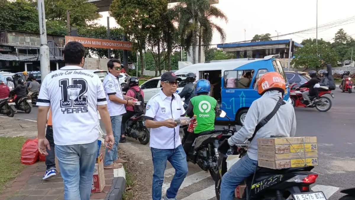 Komunitas White Car Indonesia (WCI) Betawi membagikan ratusan takjil di TMII sebagai bentuk syukur atas prestasi balap sekaligus kepedulian sosial di Ramadan 2026. (Istimewa)
