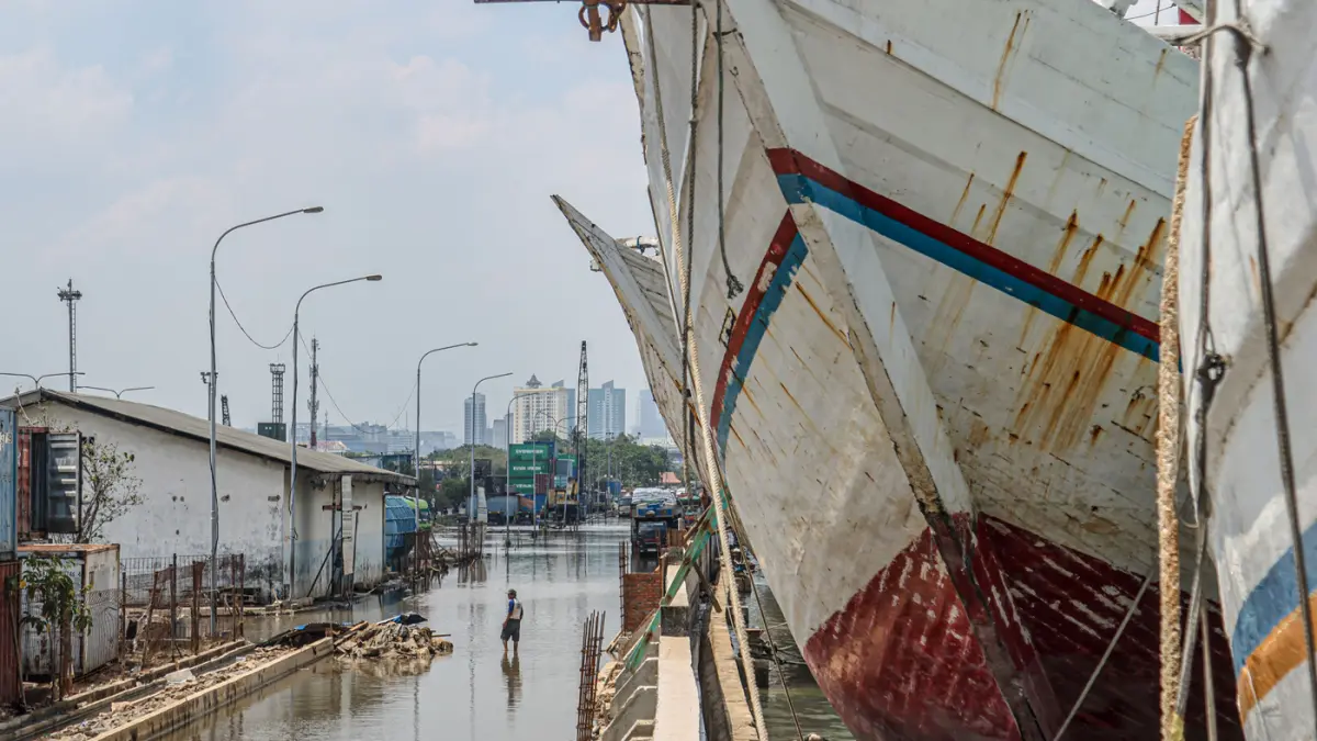 Pekerja menyelesaikan proyek pembangunan tanggul beton di Pelabuhan Sunda Kelapa, Jakarta, Selasa (14/10/2025). (Hanung Hambara/Jawa Pos)