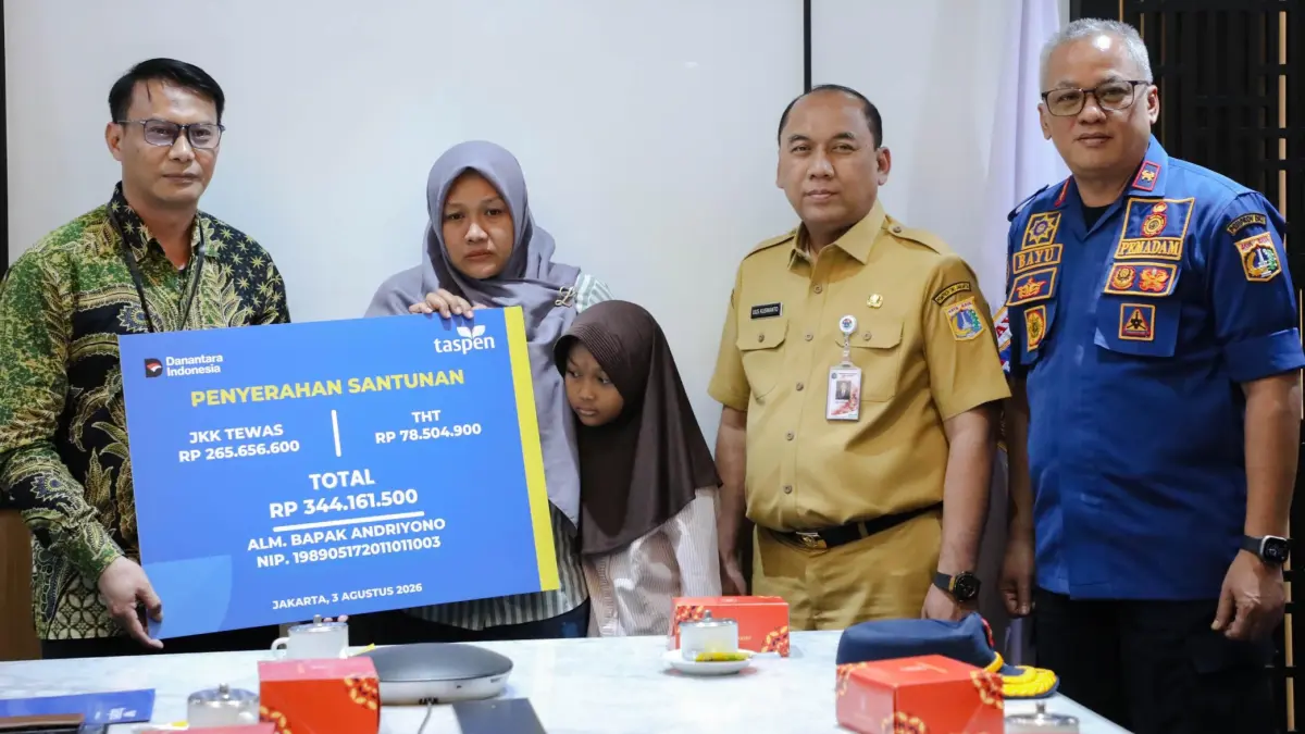Sekretaris Daerah (Sekda) DKI Jakarta Uus Kuswanto (dua dari kanan) menyaksikan penyerahan santunan Jaminan Kecelakaan Kerja (JKK) dan Jaminan Hari Tua (JHT) dari PT Taspen kepada keluarga Andriyono di Balai Kota Jakarta, Senin (3/8). (Istimewa)